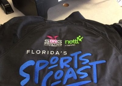 Florida Sports Coast logo embroidered on the back of the jumpsuit.